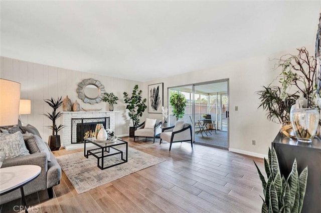 living area with baseboards, wood finished floors, and a fireplace