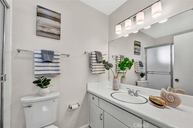 bathroom with toilet, a stall shower, and vanity