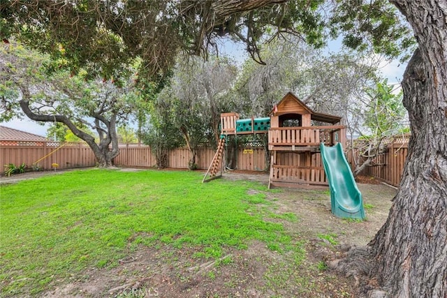 view of playground featuring a fenced backyard and a yard