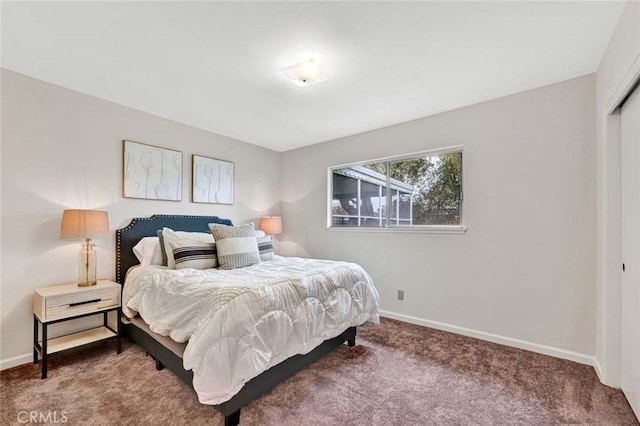 carpeted bedroom with a closet and baseboards