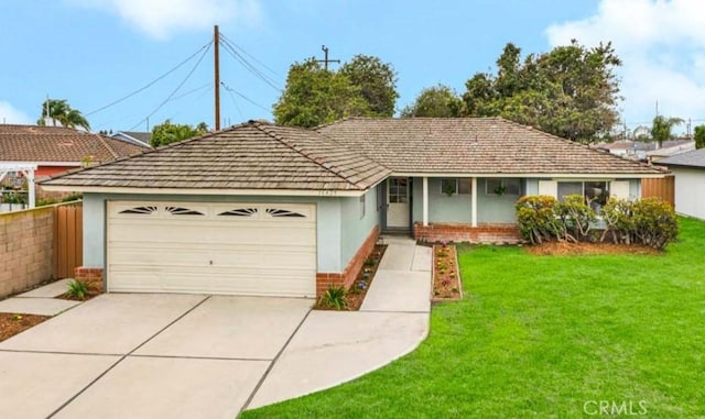 ranch-style house with stucco siding, a front lawn, brick siding, and an attached garage