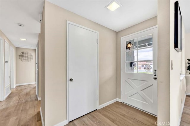 entryway with light wood-style flooring and baseboards