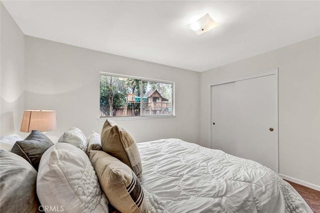 bedroom with a closet, baseboards, and carpet floors