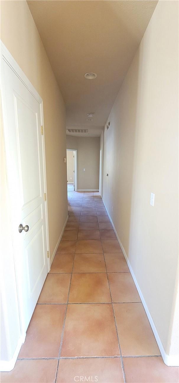 hallway featuring light tile patterned floors and baseboards