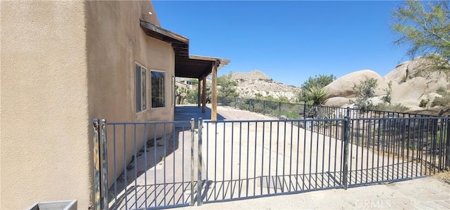 view of gate with a mountain view, a patio area, and fence