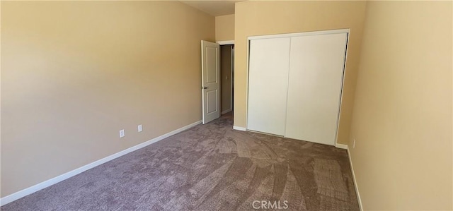 unfurnished bedroom featuring a closet, baseboards, and carpet