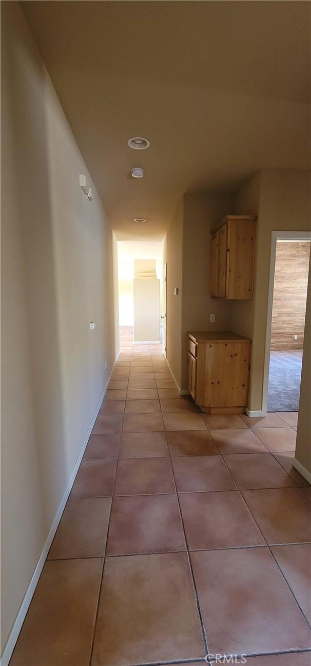 hall with light tile patterned floors and baseboards