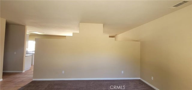 spare room featuring light tile patterned floors, visible vents, and baseboards