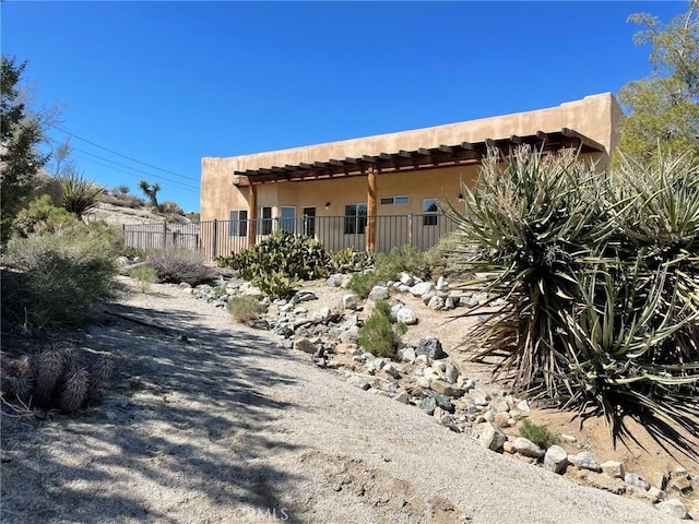 exterior space with stucco siding and fence