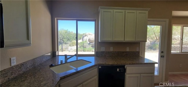 kitchen featuring a wealth of natural light, dishwasher, white cabinetry, and a sink