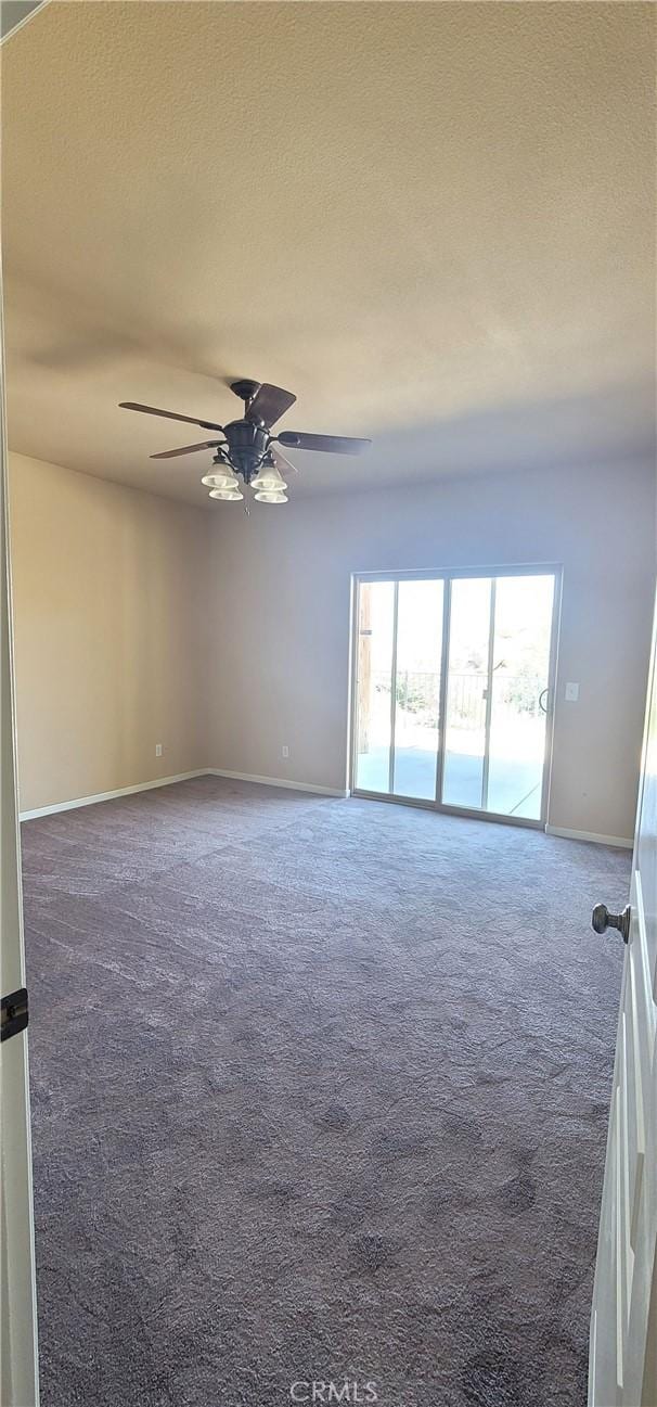 empty room with carpet flooring, a ceiling fan, baseboards, and a textured ceiling