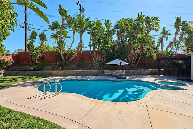 view of pool featuring a fenced backyard, a pool with connected hot tub, and a patio