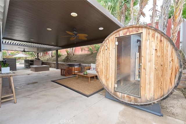 view of patio with an outbuilding, a hot tub, and ceiling fan