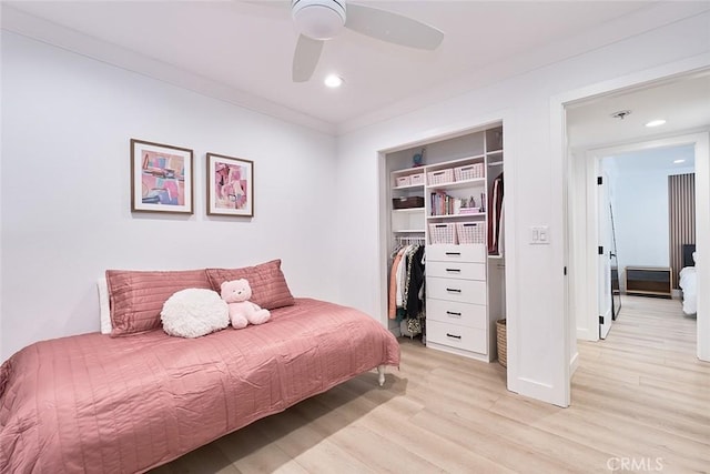 bedroom with a closet, recessed lighting, light wood-style floors, and ornamental molding