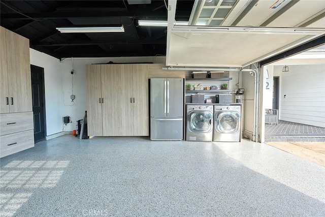 garage featuring separate washer and dryer and freestanding refrigerator