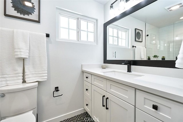 full bath with visible vents, toilet, a tile shower, baseboards, and vanity