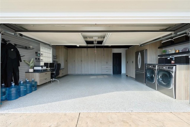 garage featuring independent washer and dryer and freestanding refrigerator