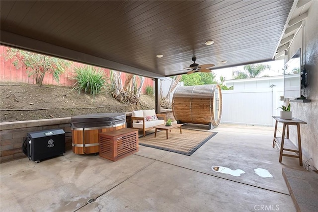 view of patio / terrace featuring an outdoor hangout area, fence, a hot tub, and ceiling fan