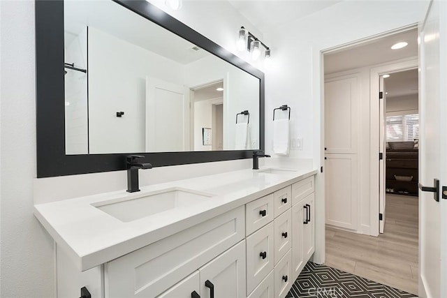 full bathroom with double vanity, recessed lighting, and a sink