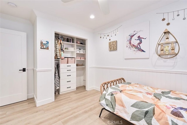 bedroom with wainscoting and crown molding