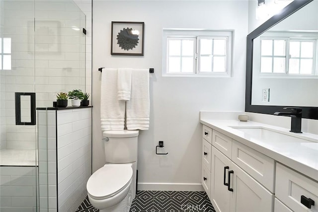 full bath with baseboards, toilet, a stall shower, and vanity