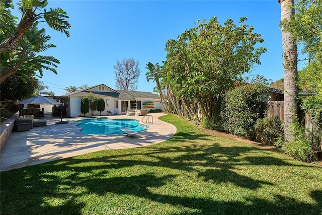 view of pool featuring a patio, a fenced in pool, a fenced backyard, a diving board, and a lawn