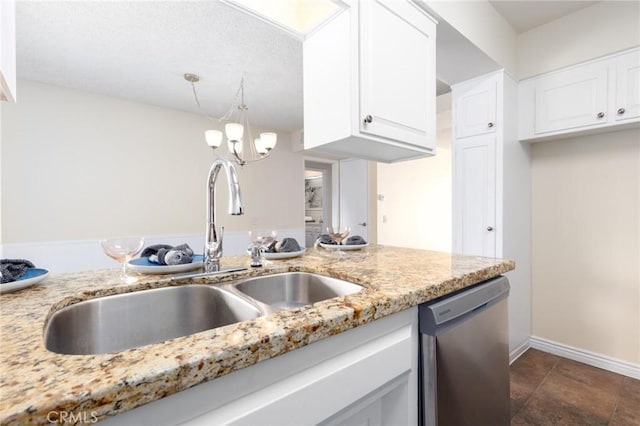 kitchen with a sink, light stone counters, stainless steel dishwasher, and white cabinetry