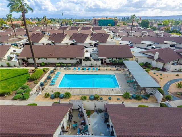 community pool featuring a patio, fence, and a residential view