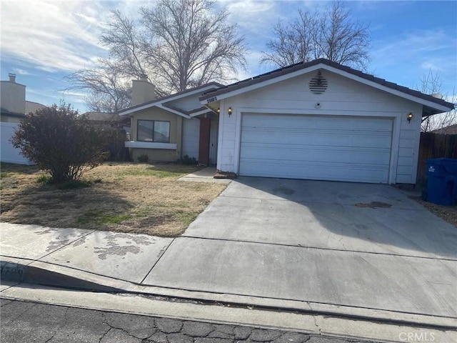 view of front of property featuring a chimney, driveway, and an attached garage