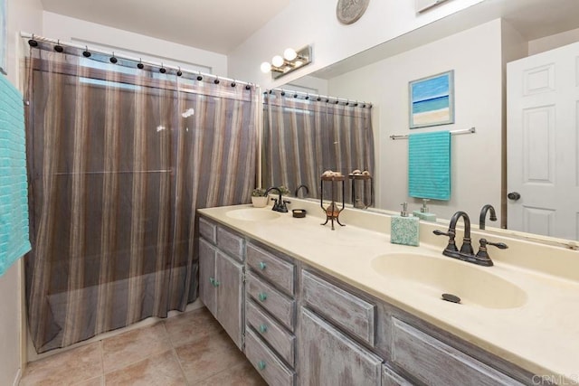 full bath with tile patterned floors, double vanity, and a sink