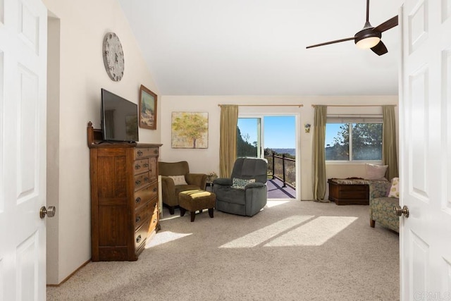 sitting room with a ceiling fan, lofted ceiling, and carpet