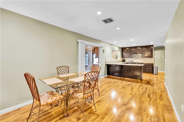 dining space featuring light wood finished floors, visible vents, recessed lighting, and baseboards