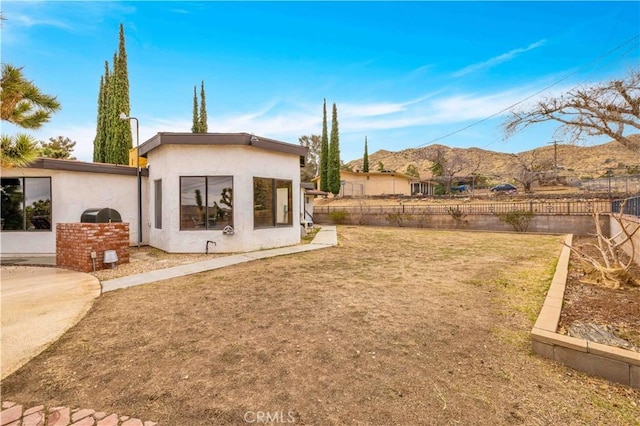 view of yard featuring a mountain view and fence