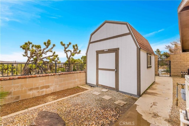 view of shed featuring a gate and fence