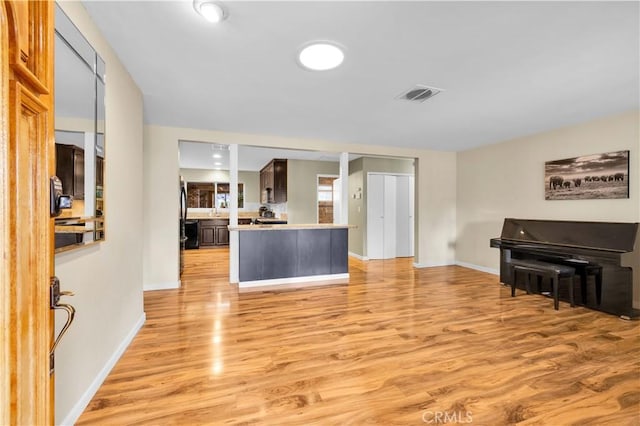 kitchen with light countertops, light wood-style floors, visible vents, and baseboards