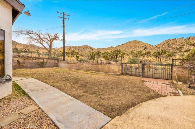 view of yard featuring a mountain view and fence private yard