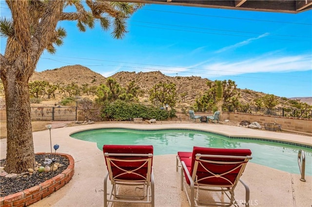 view of pool featuring a patio, a fenced in pool, a fenced backyard, and a mountain view