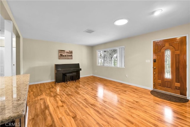 entryway with visible vents, baseboards, and light wood finished floors