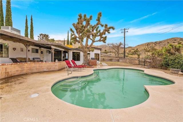 view of swimming pool with a fenced in pool, fence, central AC, a patio area, and a mountain view