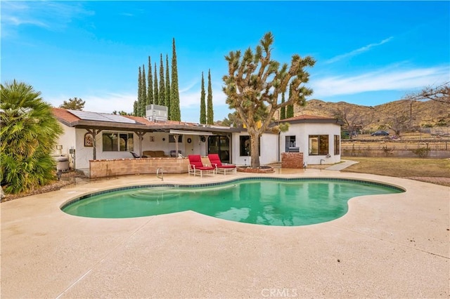 view of pool featuring a patio, a fenced in pool, and a mountain view