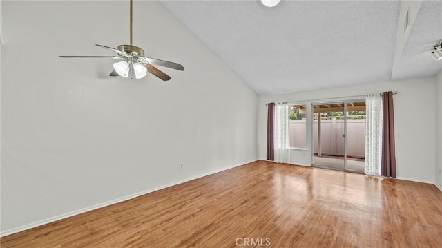 unfurnished room featuring baseboards, vaulted ceiling, wood finished floors, a textured ceiling, and a ceiling fan