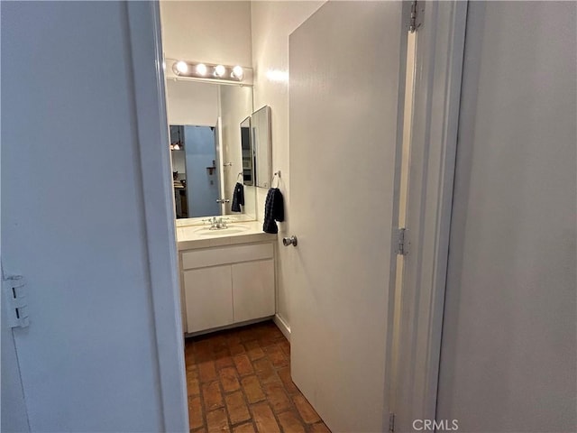 bathroom with vanity and brick floor