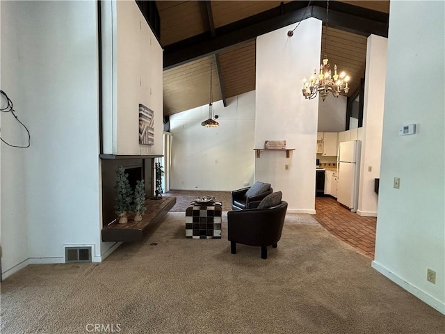 living area featuring visible vents, high vaulted ceiling, a fireplace with raised hearth, and carpet flooring