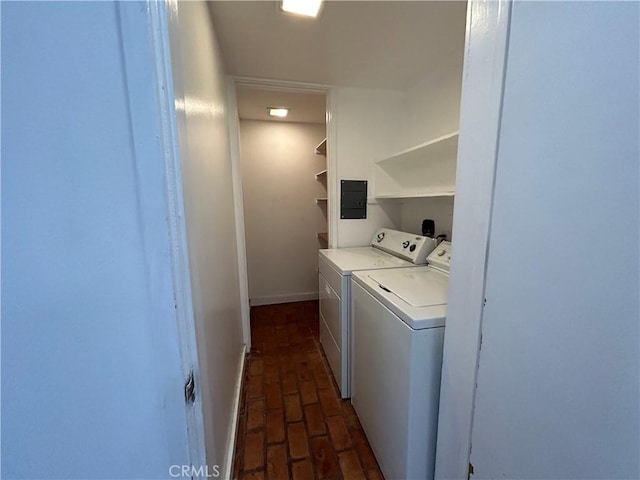 clothes washing area with independent washer and dryer, electric panel, brick floor, baseboards, and laundry area