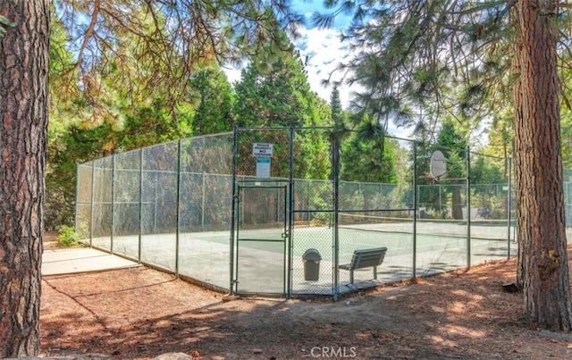 view of tennis court with community basketball court, a gate, and fence