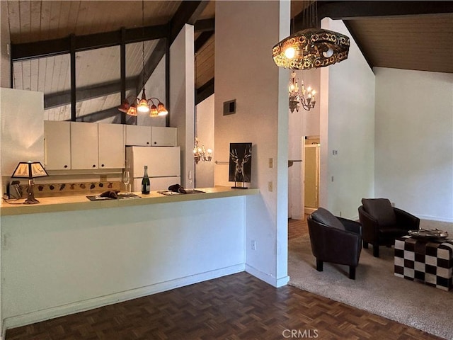 kitchen featuring visible vents, beam ceiling, freestanding refrigerator, a notable chandelier, and high vaulted ceiling