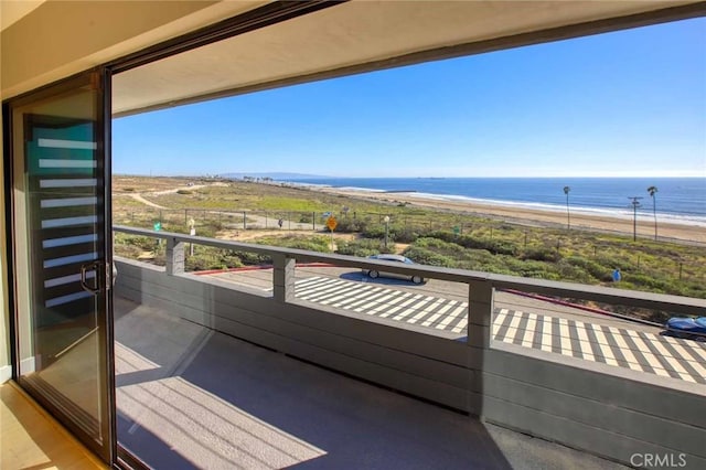 balcony with a water view and a beach view