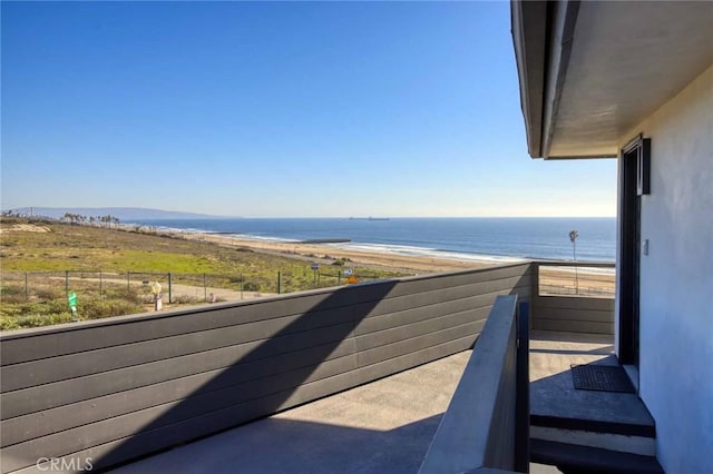 balcony featuring a beach view and a water view