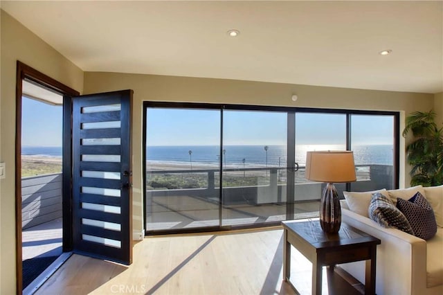 living room with recessed lighting, wood finished floors, and a water view