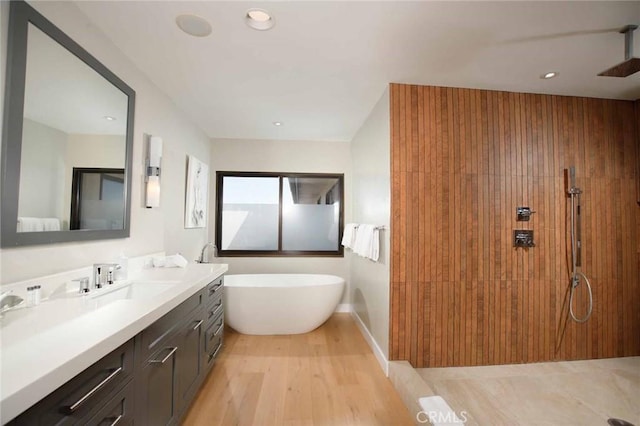 full bathroom with vanity, wood finished floors, a freestanding tub, recessed lighting, and a tile shower